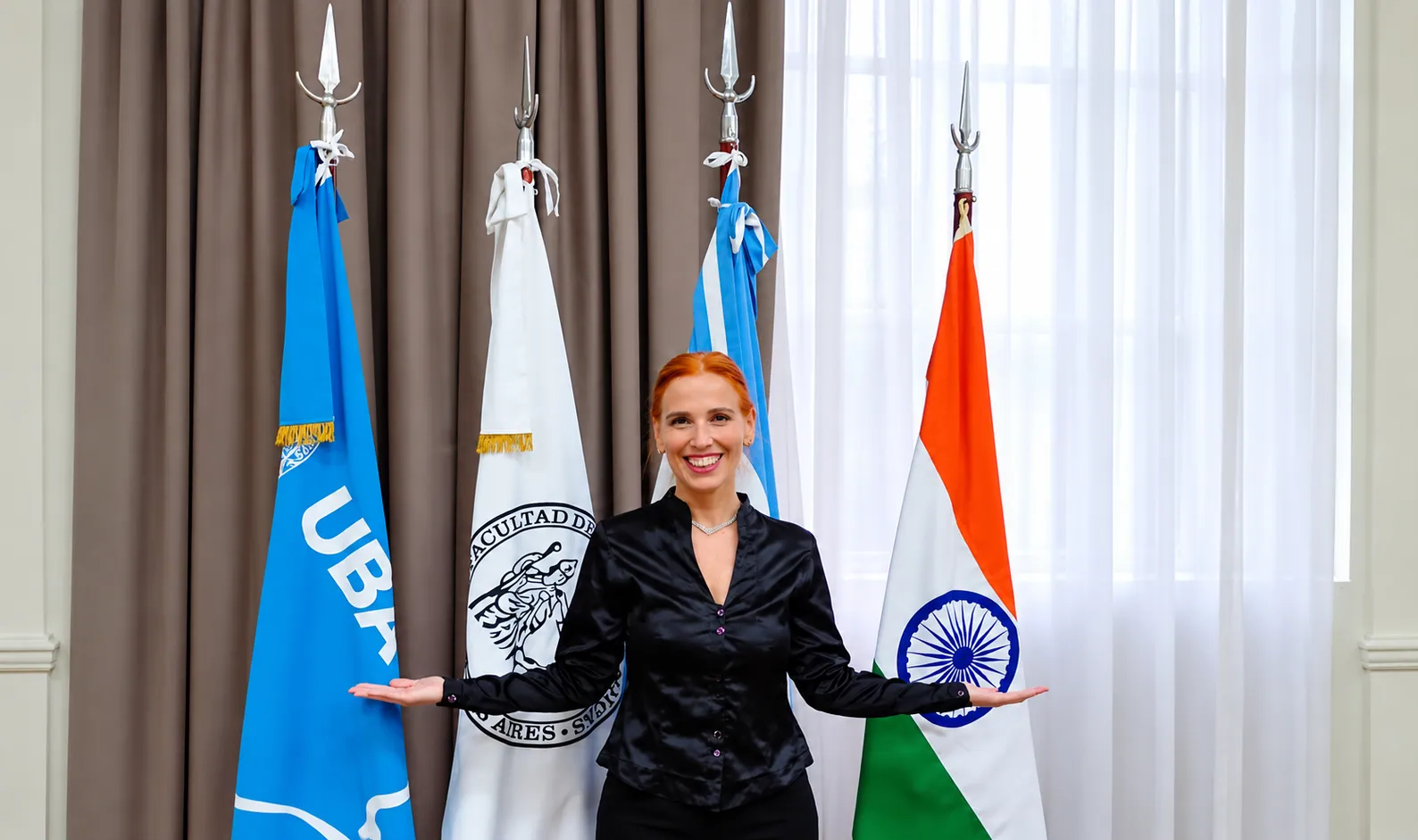 Silvina Draiman, directora del Instituto, frente a las banderas de la UBA, la Argentina y la India